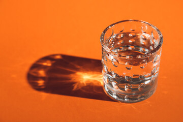 Glass of water on color background, closeup