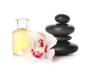 Bottle of essential oil, spa stones and flower on white background