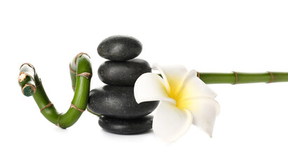 Stack of spa stones, flower and bamboo branch on white background