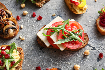 Tasty bruschettas on grunge background, closeup