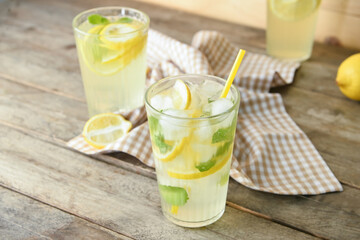 Glasses of tasty cold lemonade on wooden background