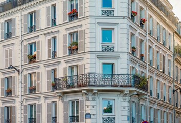 Street view of the elegant facade of an old, traditional Parisian apartment building with ornate wrought iron railings and wooden window shutters in a residential neighborhood. - obrazy, fototapety, plakaty