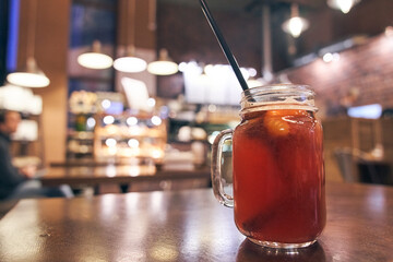 Christmas drink red non-alcoholic mulled wine with a straw on the background of the cafe interior, order for one
