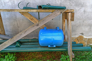 Spare equipment for the engineering system of a rural residential building on a wooden rack close-up