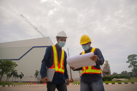 two engineer teamwork working blueprint on site construction,Engineer wear face mask protect covid19,worker work architect professional