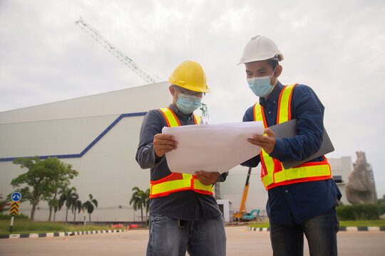 two engineer teamwork working blueprint on site construction,Engineer wear face mask protect covid19,worker work architect professional