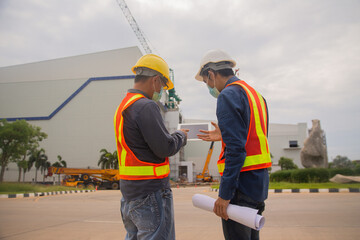 Two Engineer working tablet technology on site construction