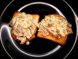Mushrooms in cream sauce with herbs on roasted toast