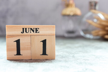 Day 11 of June month. Wooden calendar with date. Empty space for text.