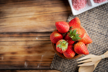 Fresh strawberries in wooden bowl.