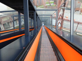 High angle shot of a descending escalator with orange stripes