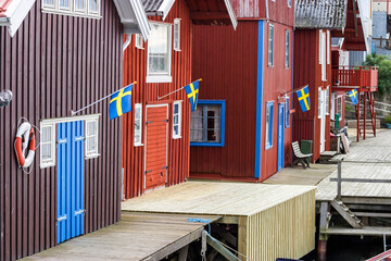 Idyllic boathouses at an old fishing village and the swedish flag