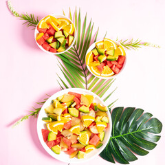 Chopped tropical fruit in bowls and plates