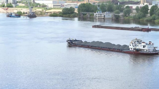 River boat tug transports a barge with sand. Dry cargo ship on the river. High quality 4k footage