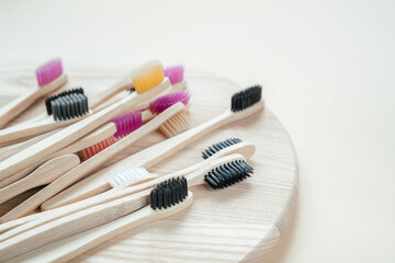 Colorful eco friendly bamboo toothbrushes on wooden tray, dental care with zero waste concept, sustainable lifestyle