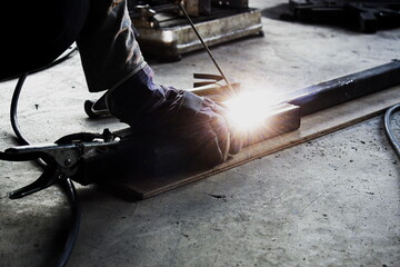 Close up of hand Professional welders in protective uniforms, welding pipes, industrial