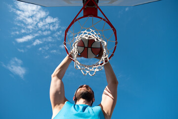 Caucasian basketball player of team in action, motion in jump on sky. Concept of sport, movement,...