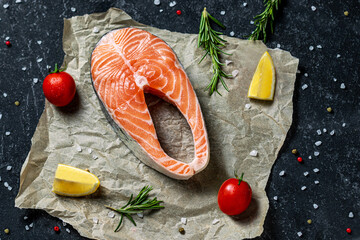 Fresh raw salmon steak with spices on rustik paper background.