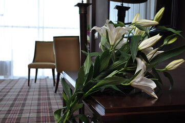 bouquet of white lilies closeup on the background of interior in retro style. Selective focus