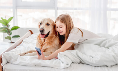 Girl with golden retriever dog and smartphone