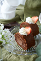 Chocolate Swiss Roll Cake with Chocolate cream filling and Strawberry set on cafe table.