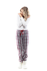 Comfy young woman in cozy pajama hugging herself in relaxation. Full body length isolated on white background.