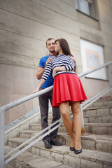 A young guy and a girl hugging on the stairs. - 435969678