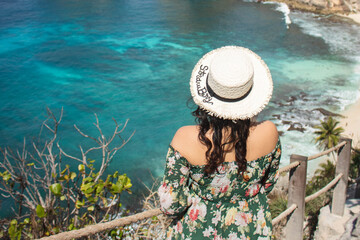 Fototapeta na wymiar Young pretty Asian woman feeling relax with mountain view at Diamond beach in Bali.