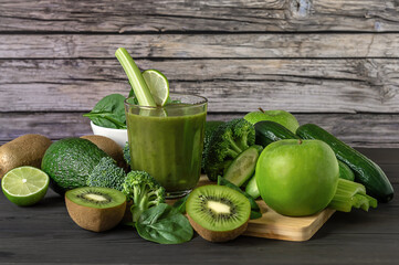 Fresh green vegetables and smoothie on wooden background