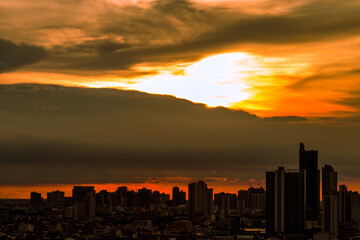 Fototapeta premium The high angle background of the city view with the secret light of the evening, blurring of night lights, showing the distribution of condominiums, dense homes in the capital community