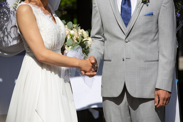 Bride With Bouquet and Groom Shaking Hands At Wedding Ceremony	