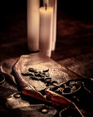 Old antique book with candle and burning smoky incense in vintage style on wooden table. Mystical concept.