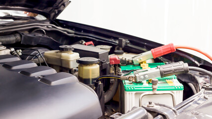 Close up Charging car battery with electricity through jumper cables.