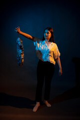 Girl in a shirt with pipidustre illuminated by complementary light