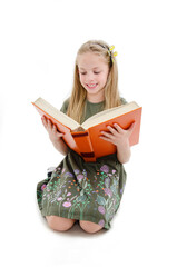 Education and school concept - adorable girl sitting on floor and reading book.  Isolated on white background
