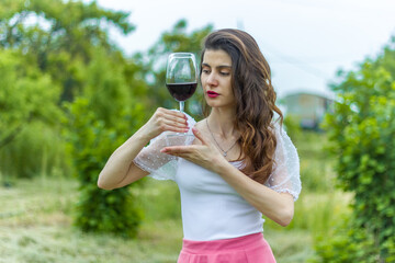 woman with wine, woman with glass of wine, woman drinking red wine in the garden