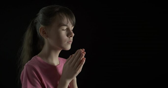 Girl ask to forgive. A pretty teen puts her hands and ask to forgive to God in the night.
