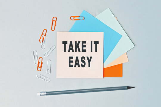 Take It Easy - Text On Sticky Note Paper On Gray Background. Closeup Of A Personal Agenda. Top View