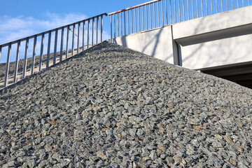 Gabion, a metal mesh filled with thick stones. Stairs for climbing to the bridge