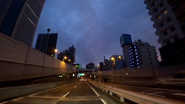 都市　高層ビル群の間を走る夜の車窓