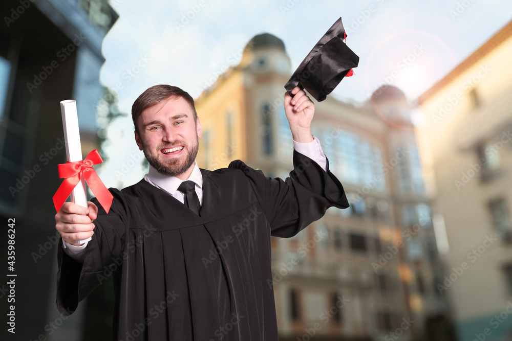 Wall mural Happy student with graduation hat and diploma outdoors