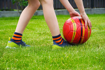   Kids sport outdoor. Child plays yard football. amateur soccer sport outside on the playing field. Close up ball lying on the grass.