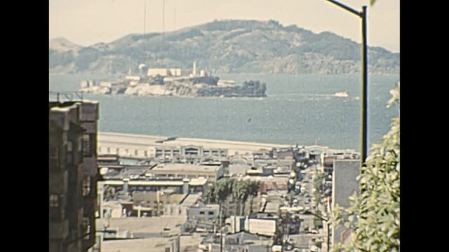 Archival view of Alcatraz island in San Francisco Bay skyline and Fisherman's Wharf and Pier 45. View from top of Taylor St in 1970s. Old California of United States in 1976.