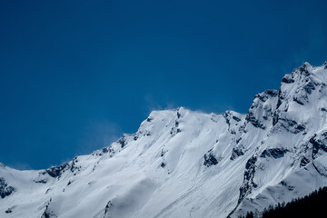strong wind weather with south wind in the alps on a sunny spring day