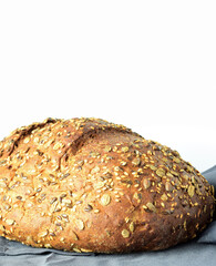 Close up. Multigrain bread on a gray cloth and white background.
Copy space.