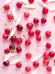 Cherry berry pattern with flowers and petals in water on pink background