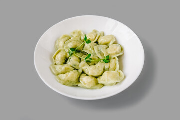 Boiled dumplings on white plate on gray.