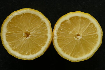 Lemon cut in half against black background
