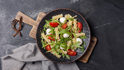 Pasta with cherry tomatoes, soft cheese and arugula leaves