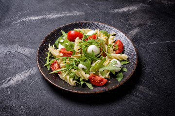 Pasta with cherry tomatoes, soft cheese and arugula leaves
